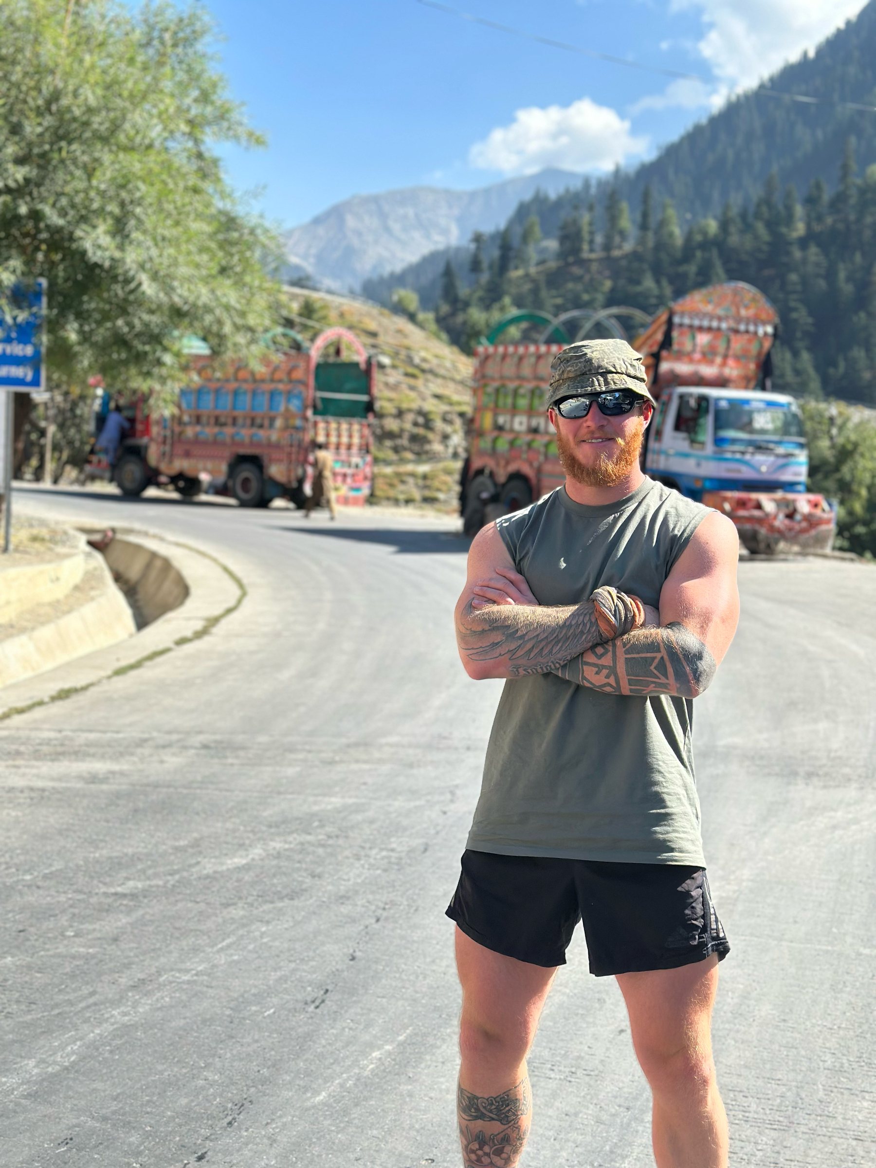 A Frontiersman on a mountain road beside painted trucks
